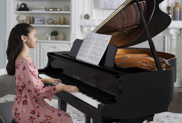 Student playing pre-owned grand piano