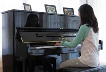 Student playing pre-owned upright piano